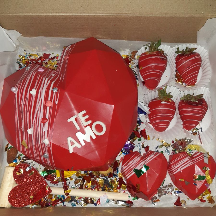 Corazón rojo de chocolate que dice Te amo, con fresas cubiertas y martillito